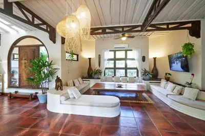 a living room with white furniture and a chandelier at Paradise Beach Lodge in Mal País