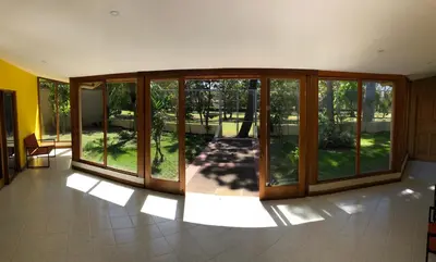 an empty room with sliding glass doors in a house at La Casa de Cariari Al Golf in Heredia