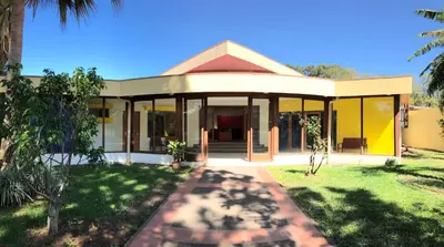 a house with glass doors and a yard at La Casa de Cariari Al Golf in Heredia
