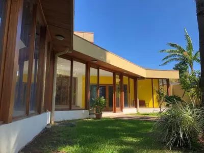 a house with a yellow facade with windows at La Casa de Cariari Al Golf in Heredia