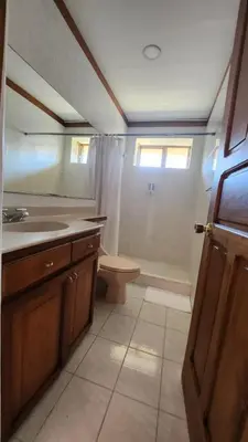 a bathroom with a toilet and a sink and a mirror at La Casa de Cariari Al Golf in Heredia