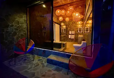 a room with two colorful chairs and a bathroom at Magic Mountain Views Studio in Atenas