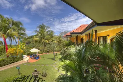 a view of a house with a yard with palm trees at Hotel Cuna del Angel in Uvita