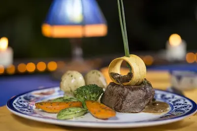 a plate with a steak and vegetables on a table at Hotel Cuna del Angel in Uvita
