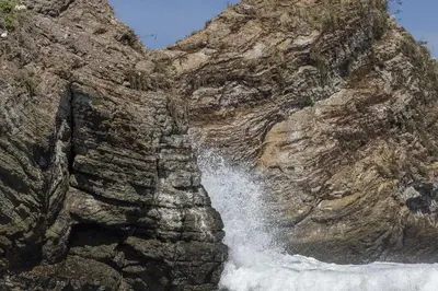 a waterfall on the side of a rocky mountain at Hotel Cuna del Angel in Uvita
