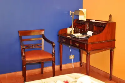 a desk with a chair and a lamp and a desk with a telephone at Hotel Cuna del Angel in Uvita