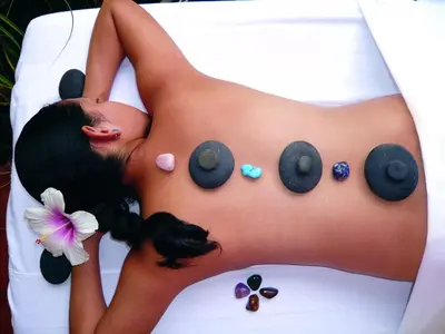 a woman is laying on a white sheet with buttons on her back at Hotel Cuna del Angel in Uvita