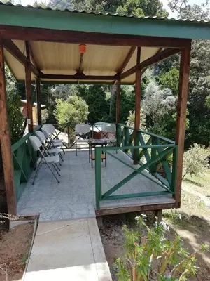 a wooden pavilion with a table and chairs at Miriam'S Quetzals lodge in San Gerardo de Dota