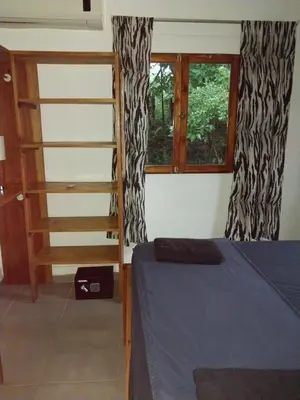 a bedroom with a bed and a ladder and a window at 1 Bedroom G-Land Burnt Toast Surfcamp in Nosara