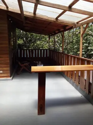 a wooden bench on a deck with a wooden roof at 1 Bedroom G-Land Burnt Toast Surfcamp in Nosara