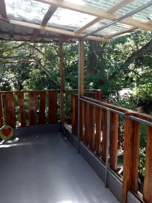 a wooden deck with a pergola and some trees at 1 Bedroom G-Land Burnt Toast Surfcamp in Nosara
