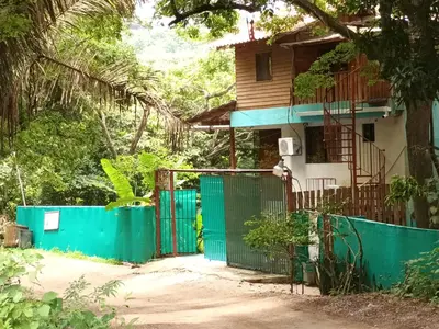 a house with a green gate in front of it at 1 Bedroom G-Land Burnt Toast Surfcamp in Nosara