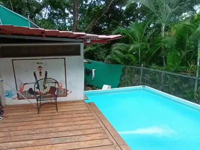 a deck with a chair and a swimming pool at 1 Bedroom G-Land Burnt Toast Surfcamp in Nosara