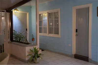 a front door of a blue house with a window at Alice y Juancito Boutique Hotel in Alajuela City