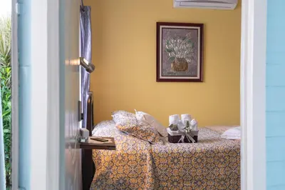 a bedroom with a bed with yellow walls at Alice y Juancito Boutique Hotel in Alajuela City