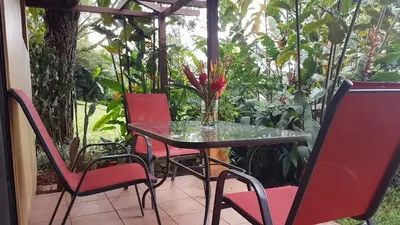 a glass table and chairs on a patio at Tacacori EcoLodge in Alajuela City