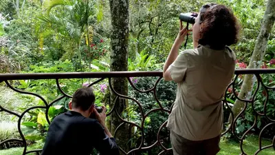 a woman taking a picture of a man on a balcony at Tacacori EcoLodge in Alajuela City