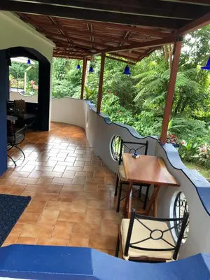 a covered patio with a table and chairs at Agua Inn in Nuevo Arenal
