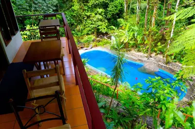 a view from the balcony of a house with a swimming pool at Agua Inn in Nuevo Arenal