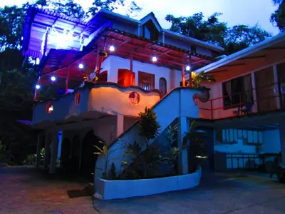 a house with lights on the side of it at Agua Inn in Nuevo Arenal