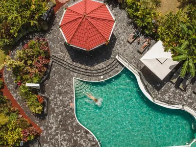 an overhead view of a pool with a red umbrella at Montaña de fuego Mountain Resort & Spa in Fortuna