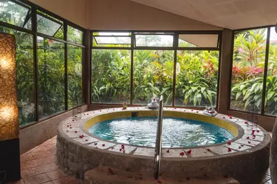 a hot tub in a room with windows at Montaña de fuego Mountain Resort & Spa in Fortuna