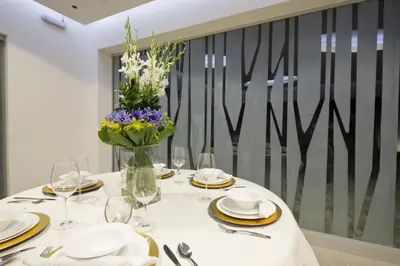 a dining room table with a vase of flowers on it at Hotel Villa Los Candiles in San José