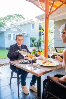 a man sitting at a table with glasses of wine at Hotel Villa Los Candiles in San José