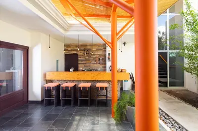 an outdoor kitchen with orange bar stools at Hotel Villa Los Candiles in San José