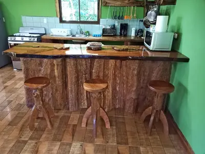 a kitchen with a wooden counter with stools at Canopy Wonders Vacation Home in Monteverde Costa Rica