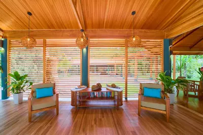 a living room with two chairs and a table at Evergreen Lodge in Tortuguero