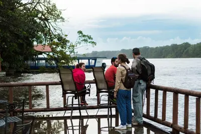 a group of people standing on a bridge near the water at Pachira Lodge in Tortuguero