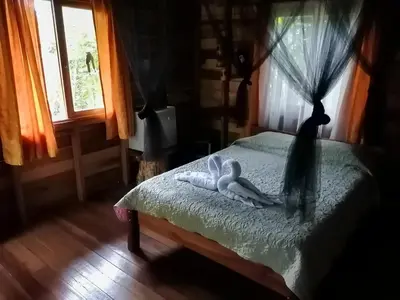 a bedroom with two towels on a bed with a window at Cataratas Bijagua Lodge, incluye tour autoguiado Bijagua Waterfalls Hike in Bijagua