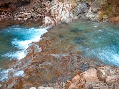 a mountain river with blue water and rocks at Cataratas Bijagua Lodge, incluye tour autoguiado Bijagua Waterfalls Hike in Bijagua