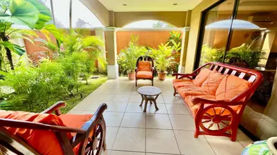 a porch with a couch and chairs and plants at Monte Carlo Luxury Condominiums in Jacó