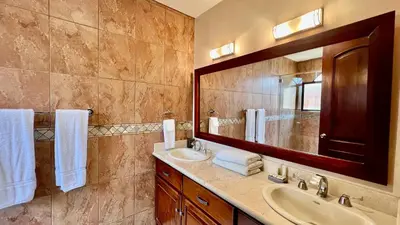 a bathroom with a sink and a mirror at Monte Carlo Luxury Condominiums in Jacó