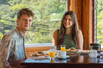 a man and a woman sitting at a table with food at Mar Inn Costa Rica in Monteverde Costa Rica