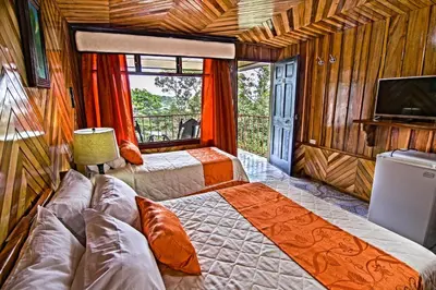 a bedroom with two beds and a flat screen tv at Mar Inn Costa Rica in Monteverde Costa Rica