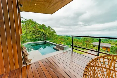 a balcony with a plunge pool on a wooden deck at Ecolirios Boutique Hotel & Villas in Guácimo