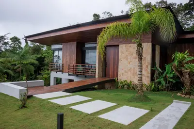 a house with a wooden deck and a yard at Ecolirios Boutique Hotel & Villas in Guácimo