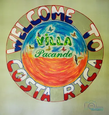 a sign with the words welcome to the world at ApartHotel Villa Pacande & Rooms in Alajuela City