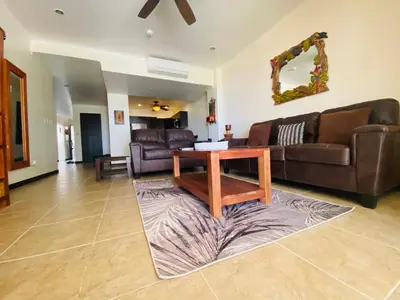 a living room with a couch and a table on a rug at Oceanfront The Palms Jaco in Jacó