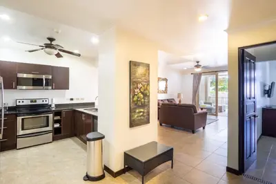 an open kitchen and living room with a couch at Oceanfront The Palms Jaco in Jacó