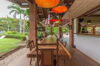 a long wooden table with chairs in a restaurant at Latica Lodge in Playa Negra