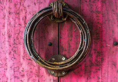 a horseshoe hanging on a pink wooden door at Latica Lodge in Playa Negra