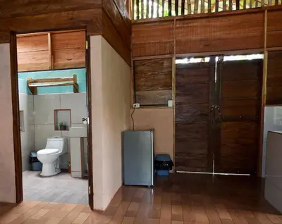 a bathroom with a toilet and a sliding door at Iguanitas Lodge in Pital