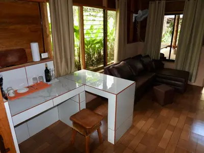 a living room with a table and a couch at Iguanitas Lodge in Pital