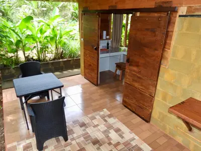 a room with a table and chairs and a kitchen at Iguanitas Lodge in Pital