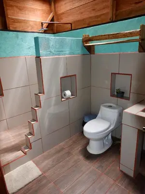 a bathroom with a toilet and a sink at Iguanitas Lodge in Pital