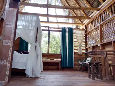 a bedroom with a bed in a room with windows at Iguanitas Lodge in Pital